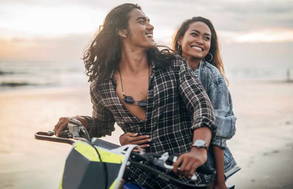 promo image for couple on a motorbike at the beach